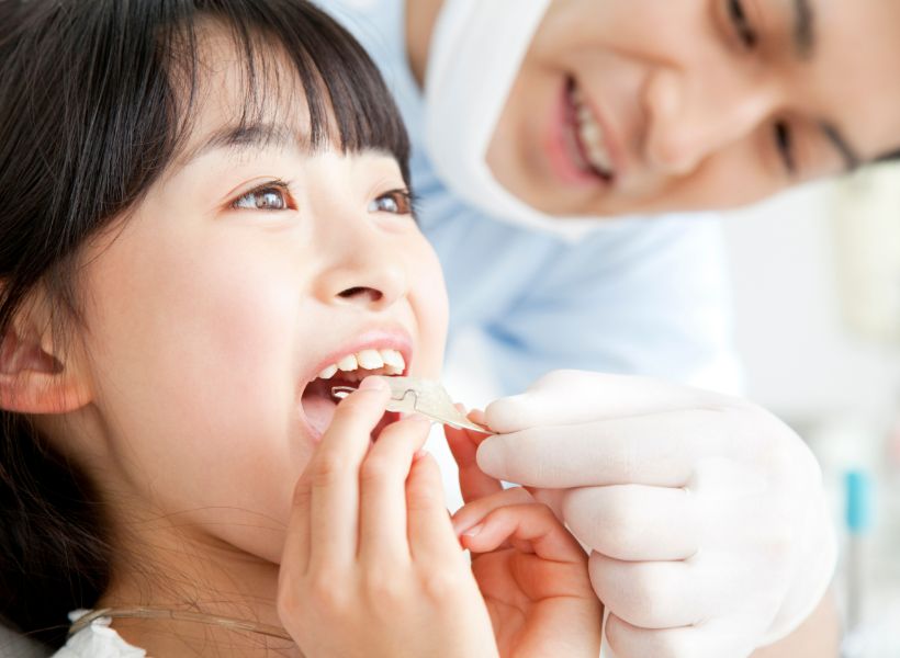 矯正器具を装着しようとしている子ども